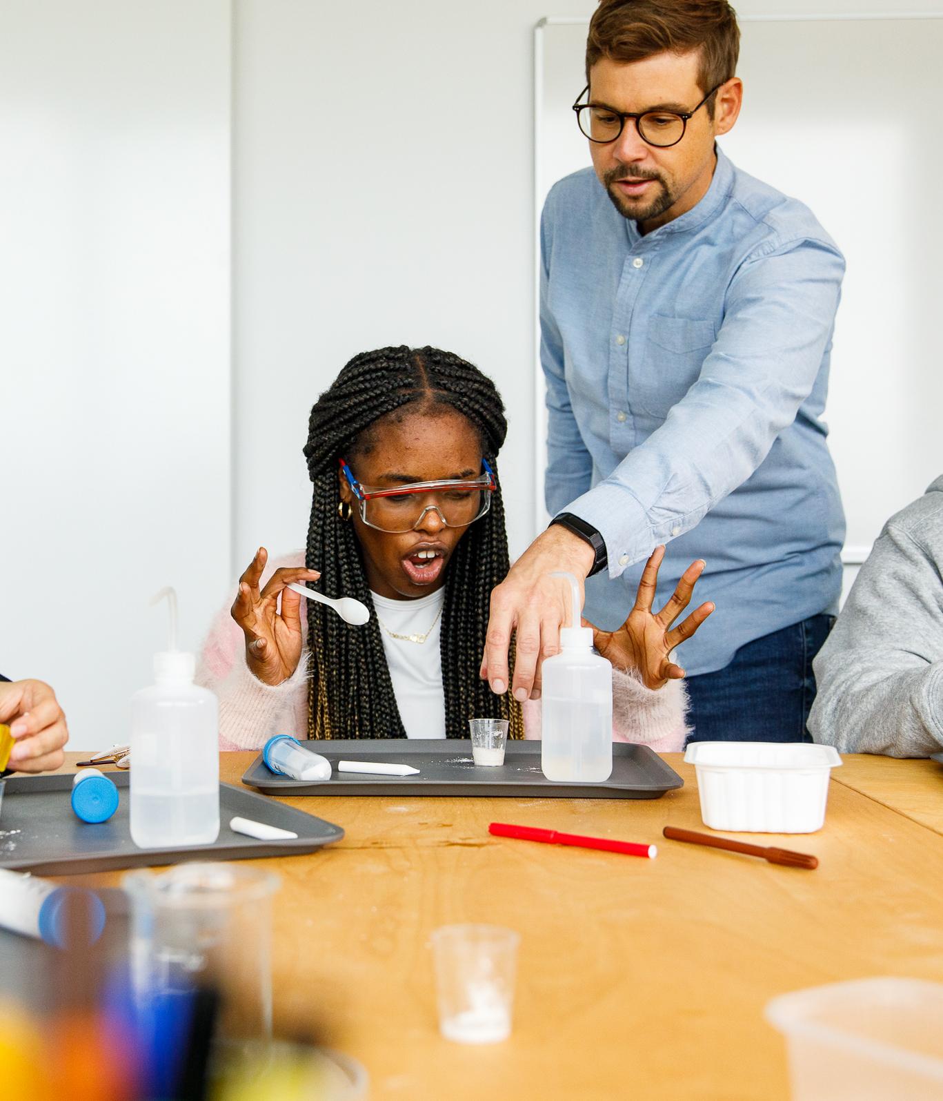 Mädchen mit Lehrer bei einem Laborversuch
